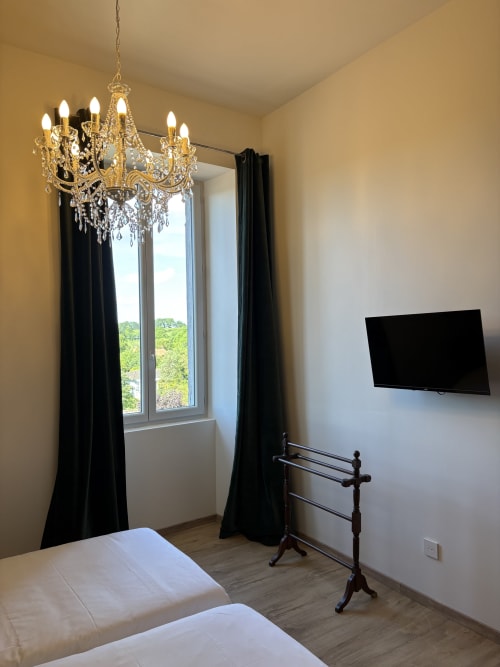 CHAMBRE 7 au B&B Le Montreal à Montréal du Gers : mobilier élégant, lustre, TV et rideaux noirs