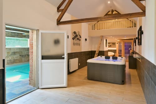 Luxuriöses Spa-Poolhaus des Ziane Hotels mit Whirlpool, sichtbaren Balken und Zugang zum Schwimmbad in der Normandie