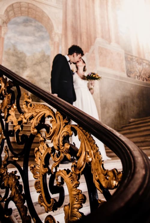 Les mariés s'embrassent sur le grand escalier du château Ô Hôtel à Hayange, France