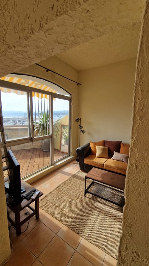 Lumineux séjour avec canapé orange, vue mer depuis la terrasse, Terrasses des Lecques, Saint-Cyr-sur-Mer