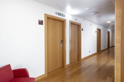 Couloir d'hôtel à Casa Azcona à Zizur Mayor avec portes en bois, murs blancs et parquet