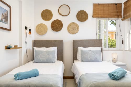 Twin bedroom with gray headboards, woven wall art, and coastal decor at MarVillas Rentals in Lagoa, Portugal