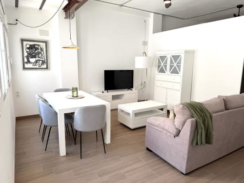 Salón moderno de apartamento en Valencia con mesa de comedor, televisor, sofá y unidad de almacenamiento blanca