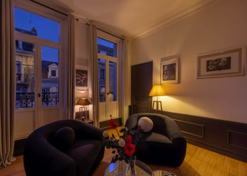 Elegant apartment living room in Epernay with city view, modern black chairs, framed art, and Parisian-style balcony doors at