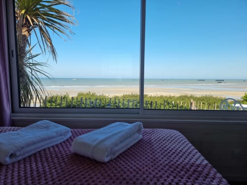 Chambre avec vue sur mer au gîte Bayeuzen, serviettes roulées, palmier et horizon marin à Saint-Côme-de-Fresné