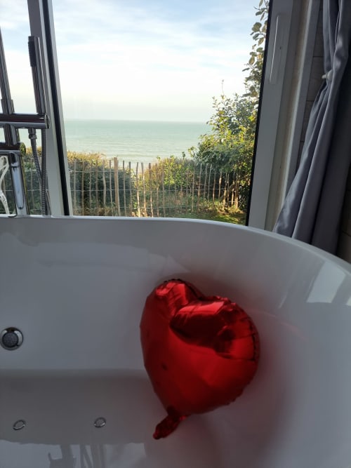 Ballon cœur rouge dans une baignoire avec vue sur la mer à la maison d'hôtes Bayeuzen, Saint-Côme-de-Fresné