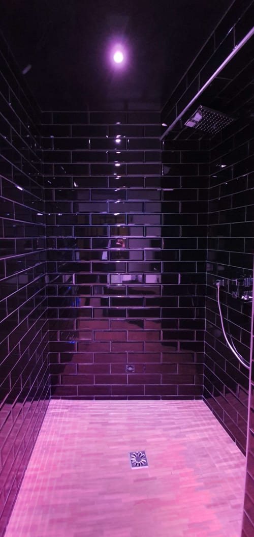 Salle de bains moderne avec éclairage néon violet, carrelage métro et douche à l'italienne à la Bayeuzen B&B à Bayeux, France
