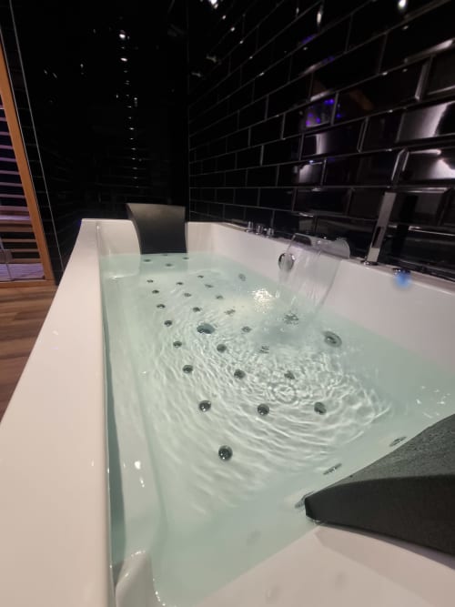 Baignoire de luxe avec jets d'hydromassage à l'appartement Bayeuzen Baldaquin à Bayeux, France
