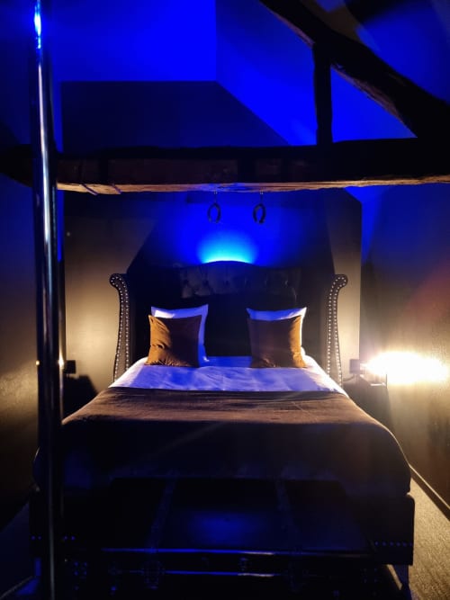 Lit à baldaquin luxueux avec éclairage ambiant bleu à la villa Le Jardin du Bayeuzen Bayeux B&B