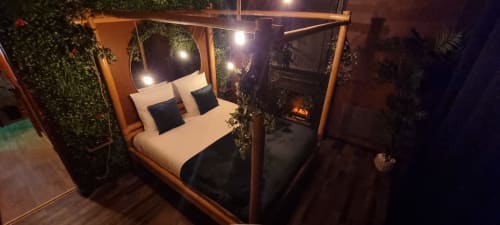 Lit à baldaquin luxueux à la villa La Tropicale de l'hôtel boutique Bayeuzen, Bayeux, avec éclairage d'ambiance et décor tropical