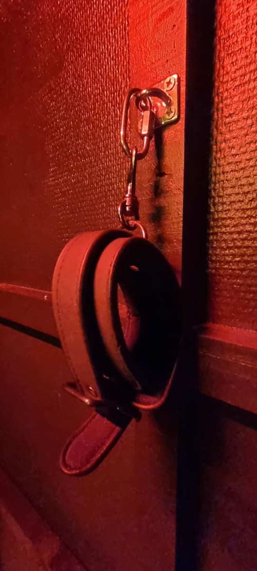 Enrouleur de tuyau d'incendie rouge fixé sur mur texturé rouge à la villa La Tropicale, Bayeux