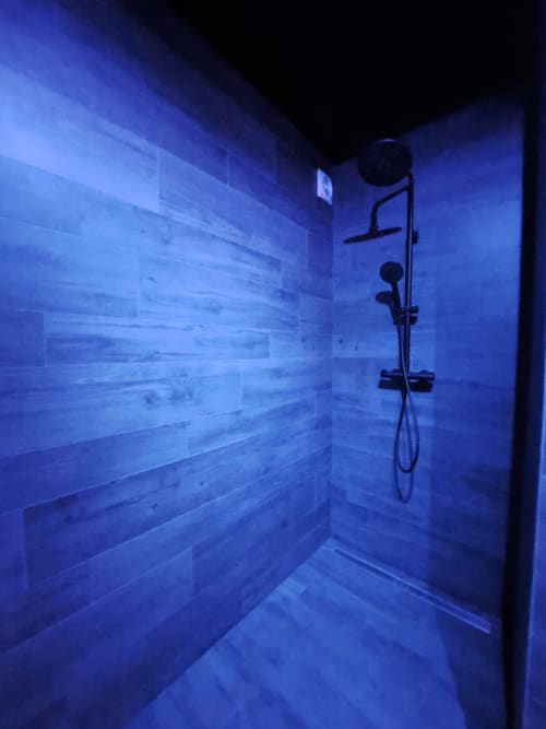 Salle de bain moderne avec éclairage bleu à la villa La Tropicale à Bayeuzen, Bayeux, dotée de pommeaux de douche pluie et portatifs