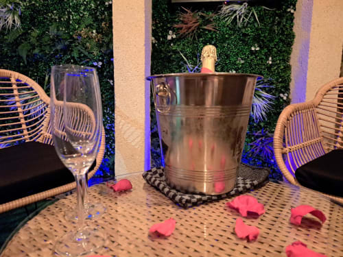 Élégant seau à champagne avec bouteille et verre de vin sur table de patio à la villa Bayeuzen à Bayeux, France