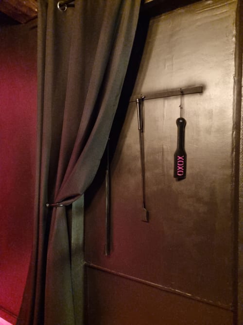 Chambre intimiste style donjon à la villa Bayeuzen à Bayeux avec accessoires en cuir suspendus et rideaux drapés