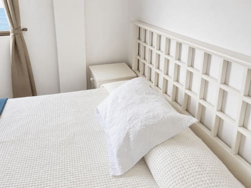 Dormitorio luminoso en apartamento Restinga Vista Mar, Tenerife con cama blanca, cabecero acolchado y vistas al mar