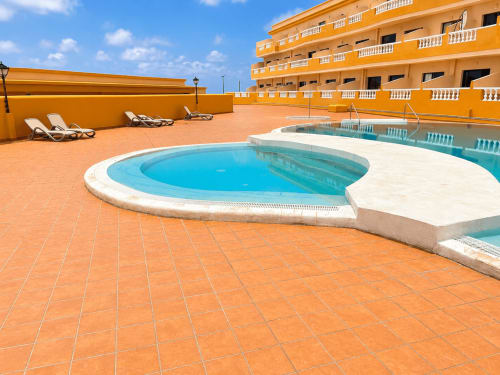 Área de piscina en la azotea de Restinga Vista Mar en Tenerife con tumbonas, baldosas de terracota y vistas al mar