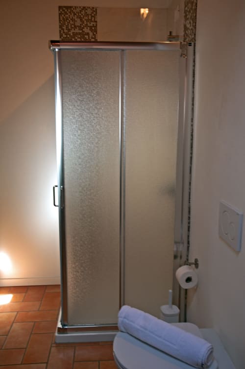 Doccia con porte in vetro satinato nella camera Corte delle Giuggiole, bagno moderno ben attrezzato