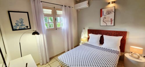 Chambre lumineuse au Nid De Bellemont à Trois-Rivières avec tête de lit rouge, vue sur la mer, art moderne et climatisation