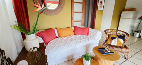 Chambre colorée du Le Nid De Bellemont avec lit blanc, décor tropical et vue sur mer à Trois-Rivières