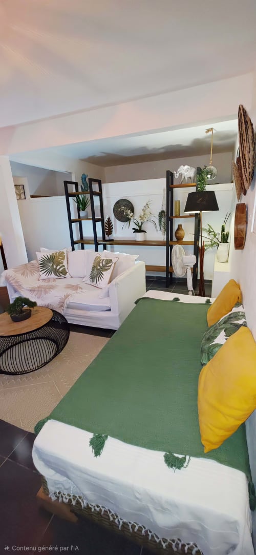 Chambre cosy du Nid De Bellemont avec lit vert, canapé rose, plantes et étagères modernes à Trois-Rivières