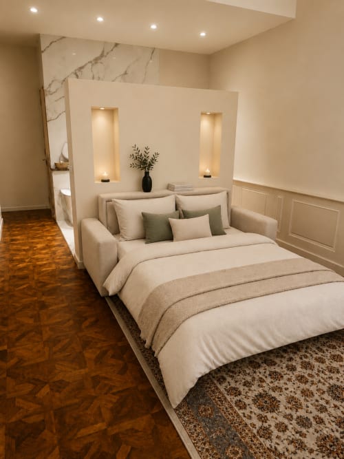 Luxury bedroom at Les Suites de Montigny, Aix-en-Provence, with cream bedding, marble accent wall, and warm lighting