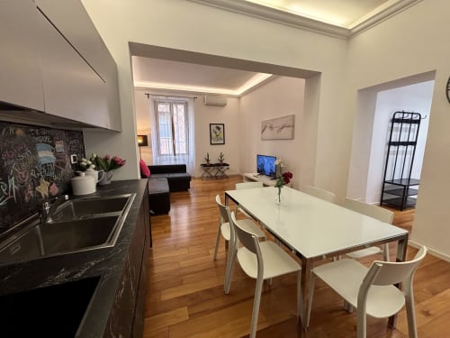 Moderno appartamento romano con cucina aperta, tavolo da pranzo e zona living presso Domus Caecilia, via Cola di Rienzo