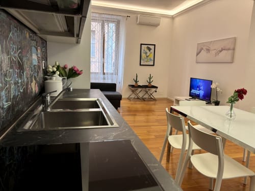 Appartamento moderno a Roma presso Domus Caecilia con cucina aperta, zona pranzo e soggiorno con pavimenti in legno
