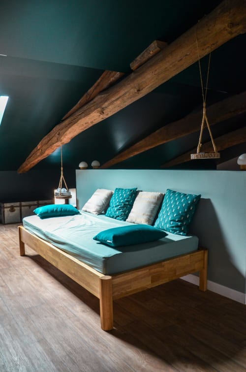Rustic bedroom with wooden beams, turquoise accents, and wooden bed frame at La Maison d'Augustin, Mont-de-Marsan