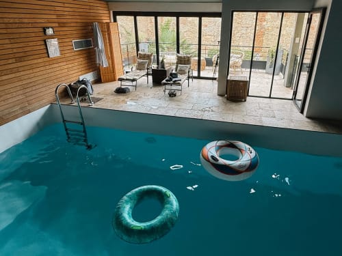 Indoor pool with floaties at La Maison d'Augustin family apartment in Mont-de-Marsan, France