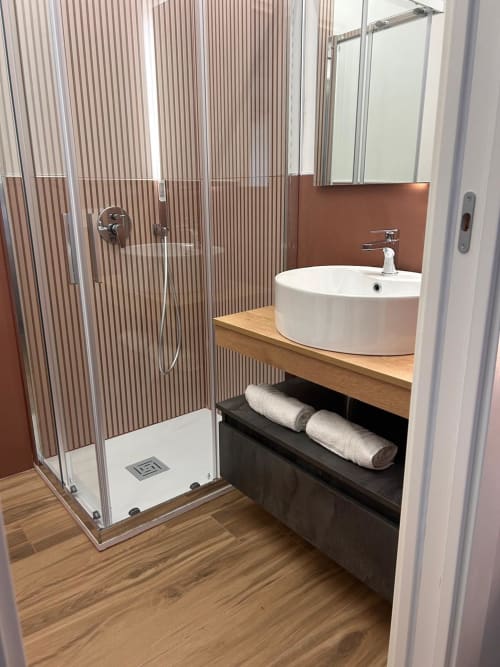 Bagno moderno dell'Anima Est B&B Napoli con doccia a pioggia, lavabo rotondo, mobile in legno e scaldasalviette