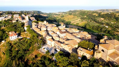 Vista aerea di Campofilone, pittoresco borgo collinare italiano con edifici storici in pietra e paesaggio rurale ondulato