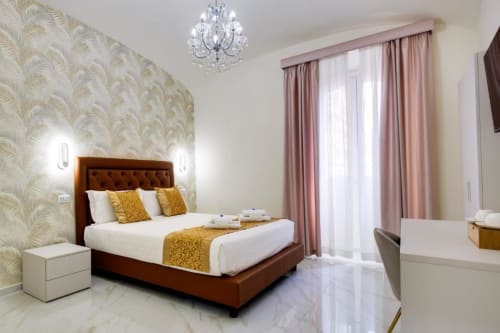 Lussuosa Camera Deluxe con Letto King al Domus Praeclara Merulana di Roma, con elegante letto marrone con finiture dorate e