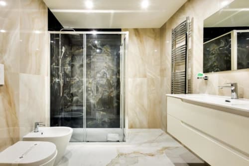 Bagno moderno in Superior King Room al Domus Praeclara Merulana di Roma, con piastrelle in marmo, doccia in vetro, bidet, lavabo e