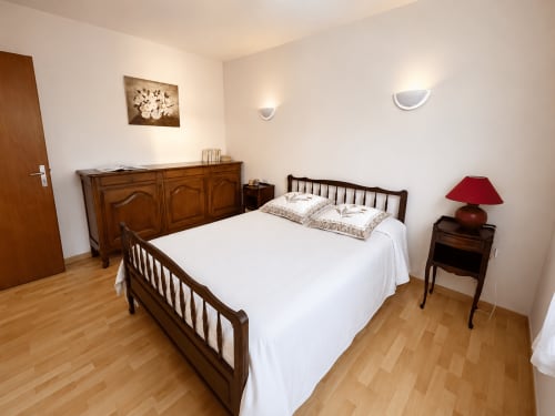 Chambre accueillante de l'Appartement T2 EST à la Location Côte Landes, Mimizan, avec lit en bois et mobilier