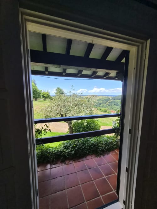 Private terrace view from Posada Torre del Milano room in Comillas, overlooking green valleys and coastline