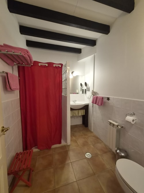 Modern bathroom at Posada Torre del Milano, Comillas with red shower curtain and dual sink vanity