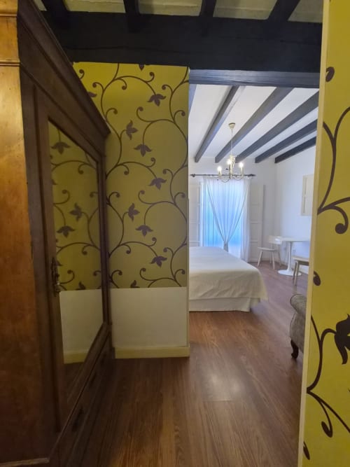 Hallway entrance to double room with sea view at Posada Torre del Milano, Comillas, with yellow patterned walls