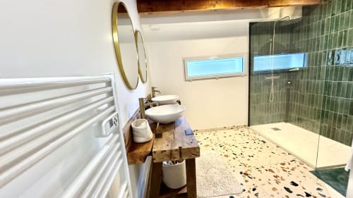 Salle de bain moderne de la villa LOCATION COTE LANDES avec vasque, douche carrelée verte et sol en terrazzo
