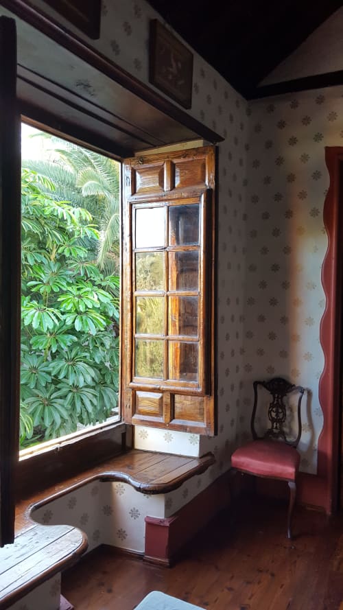 Habitación vintage del Hotel Cortijo San Ignacio en Telde con ventana de madera, vista al jardín y papel tapiz con motivos