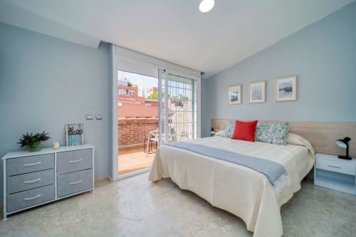 Dormitorio moderno en la casa de huéspedes Suki House en Pozuelo de Alarcón con cama doble, acceso a terraza y decoración azul claro