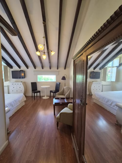 Spacious double room at Posada Torre del Milano in Comillas with beamed ceiling, wooden floors, twin beds, and sea view