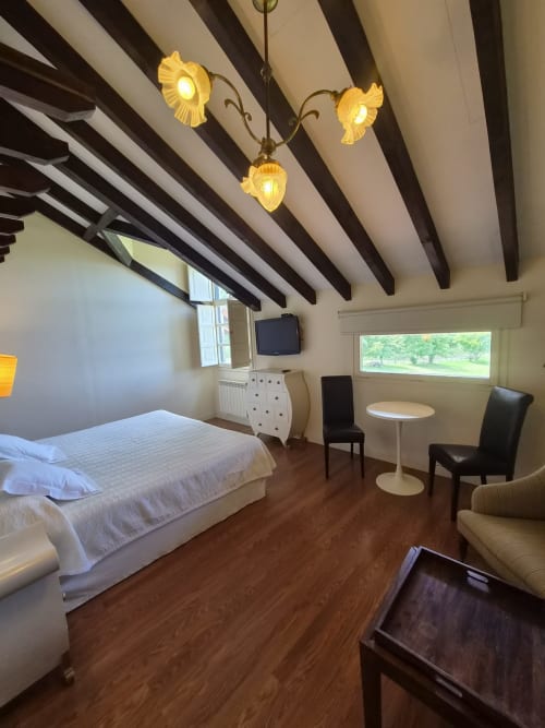Spacious double room at Posada Torre del Milano in Comillas with exposed beams, sea views, and modern amenities