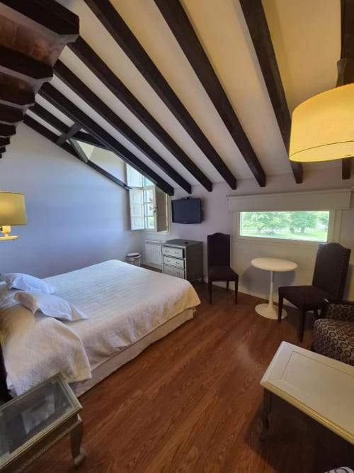 Spacious double bedroom at Posada Torre del Milano in Comillas with exposed beams, sea views, and modern amenities