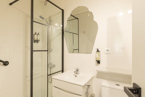 Modern bathroom at Charme da Graça hotel in Costa de Caparica, Lisboa, with shower, sink, and mirrors