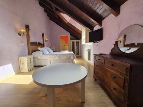 Spacious double room at Posada Torre del Milano in Comillas with purple walls, wooden beams, and ocean views