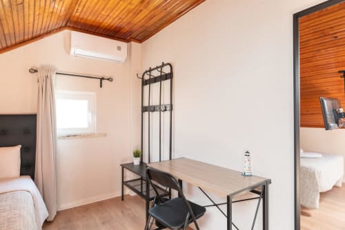 Charme da Graça hotel room in Costa de Caparica with desk, bed, wooden ceiling, and AC unit