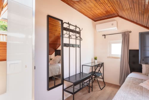 Modern bedroom at Charme da Graça hotel in Costa de Caparica, featuring twin beds, work desk, AC, and flat-screen TV