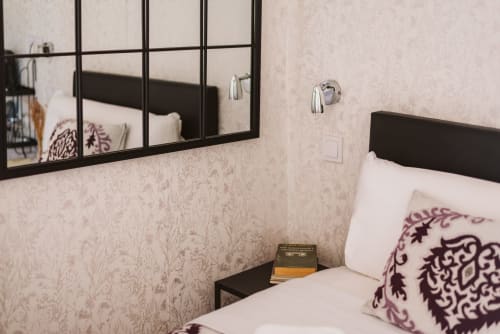 Modern single bedroom at Charme da Graça hotel in Lisbon with black framed mirror, decorative pillows, and en-suite bathroom