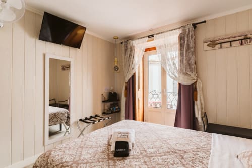 Charme da Graça hotel room in Lisboa with double bed, balcony, TV, and cream-colored wood paneling