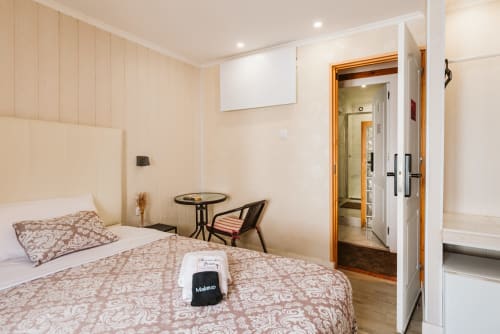 Charme da Graça hotel room in Lisbon with double bed, neutral decor, and modern bathroom entrance